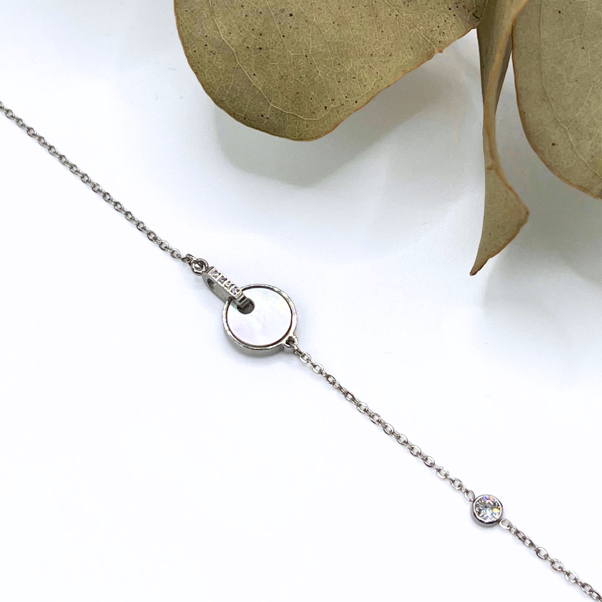 Collier argenté en acier inoxydable avec un pendentif rond orné d'une pierre de nacre avec de petits oxydes de zirconium
